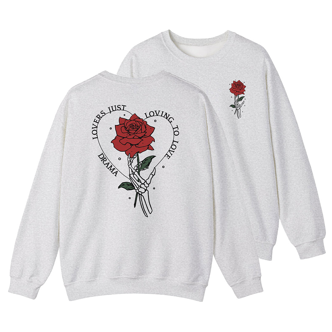 Light gray DRAMA Lovers Crewneck with a hand holding a red rose, green leaves, and “Lovers Just Loving to Love” lettering on the back.