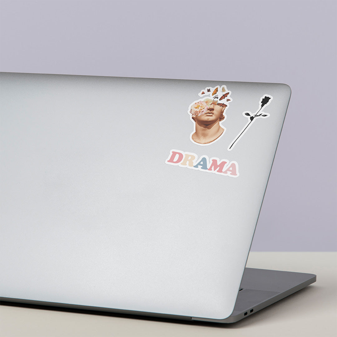 DRAMA All Day I Dream About Drama Sticker on the front of a laptop with two other sticker designs