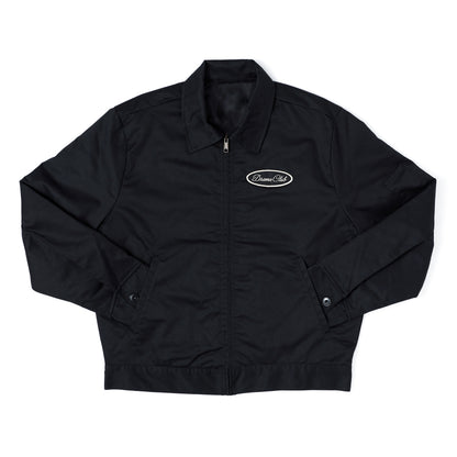 A black zip-up jacket with a stand collar, featuring a small white oval 'Dreamers Club' logo on the left chest, laid flat against a white background.